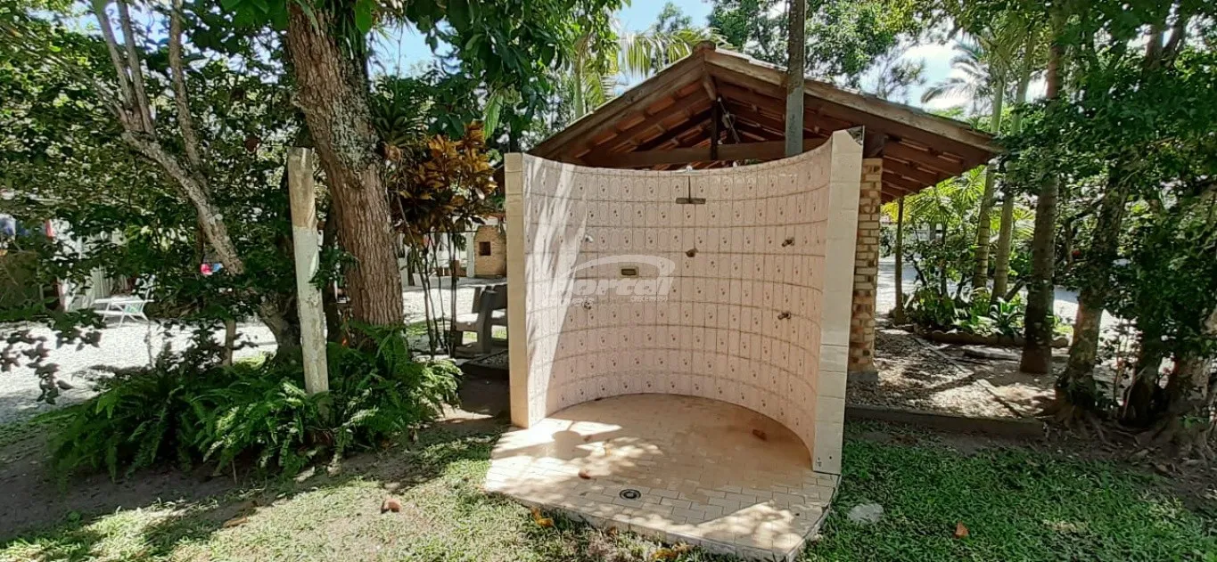 Casa com 2 dormitórios sendo uma suíte com hidromassagem, 2 banheiros, área de serviço, garagem coberta, piscina, salão de festas com churrasqueira e grande espaço nos fundos de área coletiva com árvores. — foto 7